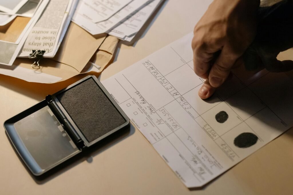 Person being fingerprinted on official criminal record form, symbolizing the legal consequences of an assault charge in Ontario.